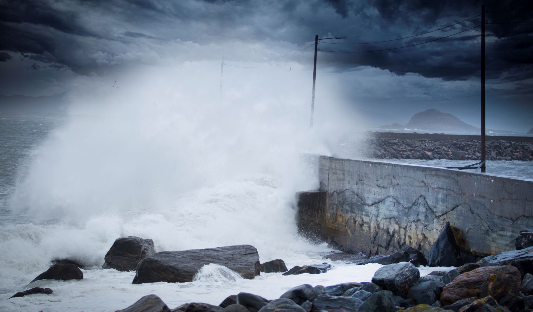 Storm på Alnes i Møre og Romsdal, bølger skyller inn over kaia.