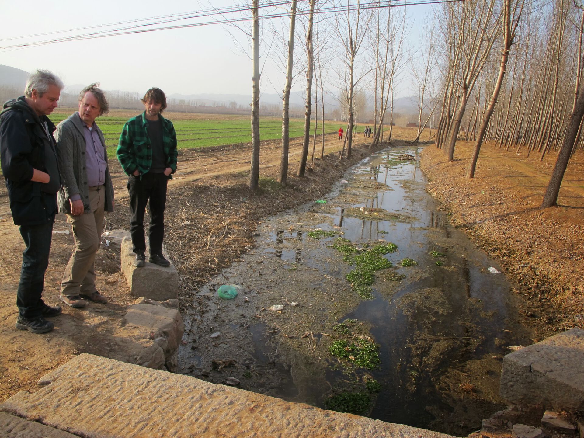 Professor Rolf David Vogt med kolleger studerer en forurenset bekk i et kinesisk jordbruksområde.
