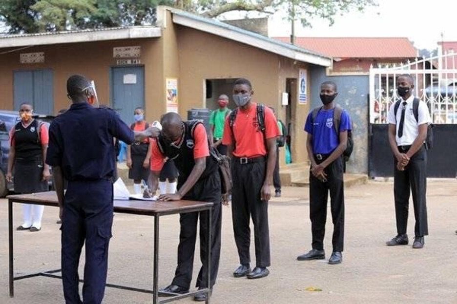 Elever ved en skole i Uganda står i kø for temperaturmåling før skoledagen.