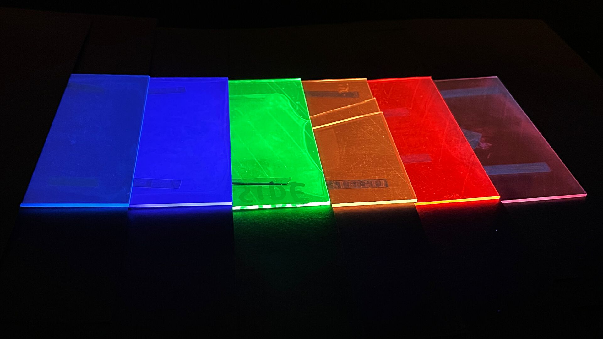 Ulike glassplater som er belagt med stoffer som konverterer UV-lys til synlig lys i ulike farger